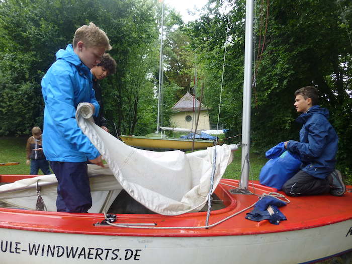 Kinder eines Segelcamps Bodensee hissen das Segel