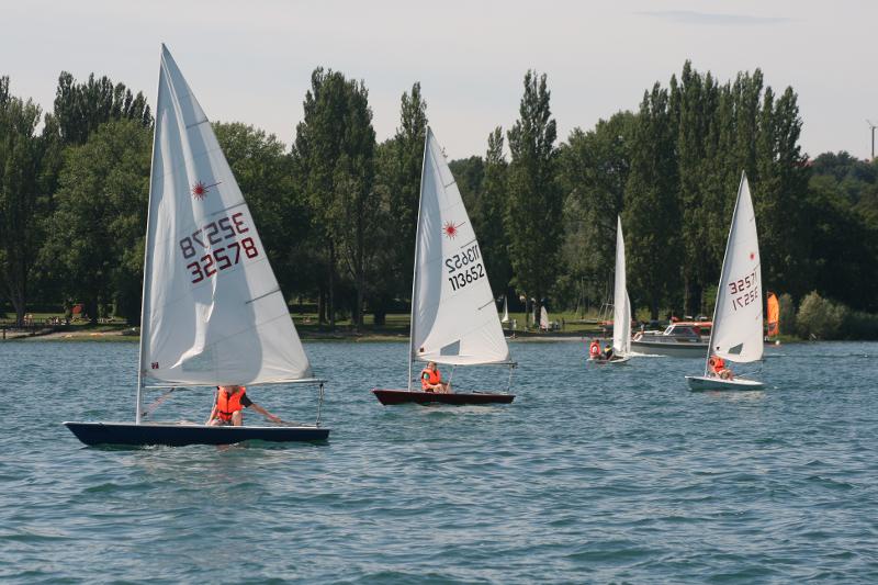 Vier Segelboote fahren im Ferienlager ab 10 über einen Fluss