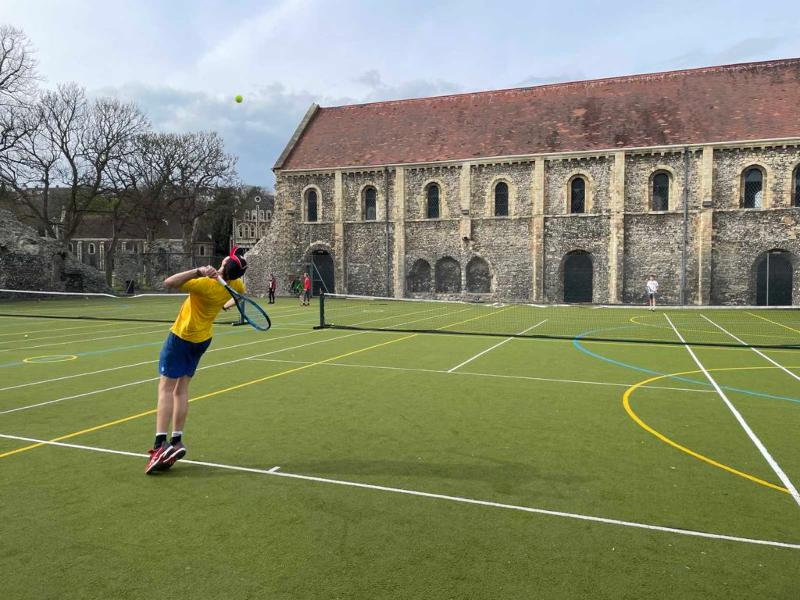 Zwei Jungen liefern sich ein packendes Duell auf dem Tennisplatz vor einer wundervollen antiken Kirche bei den Sprachreisen Großbritannien
