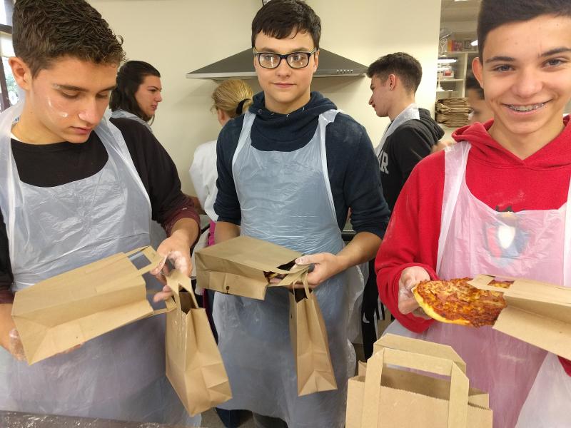Teilnehmer der Sprachreise Großbritannien halten Tüten mit Pizza in der Hand