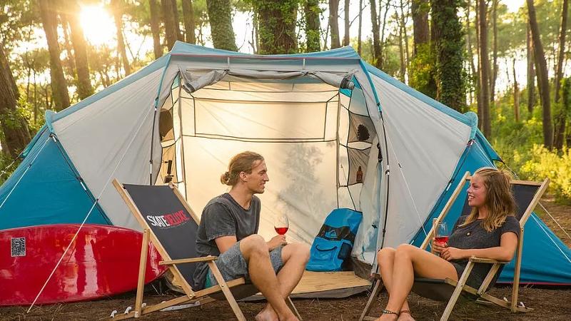 Zwei Jugendliche chillen vor ihrem Zelt im Surf-Camp Frankreich