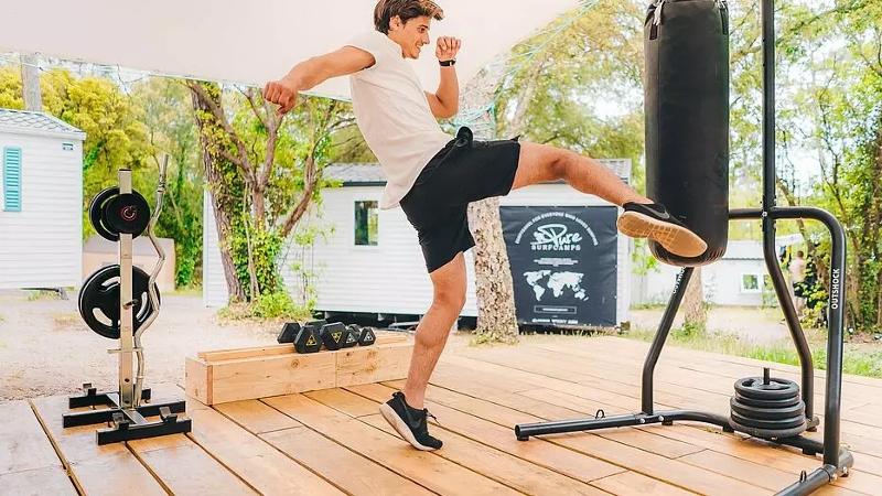 Ein Junge tritt im Surf-Camp Südfrankreich gegen einen Boxsack