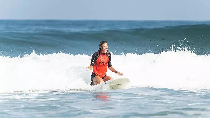 Ein Mädchen surft und hat im Surf-Camp Südfrankreich eine Menge Spaß