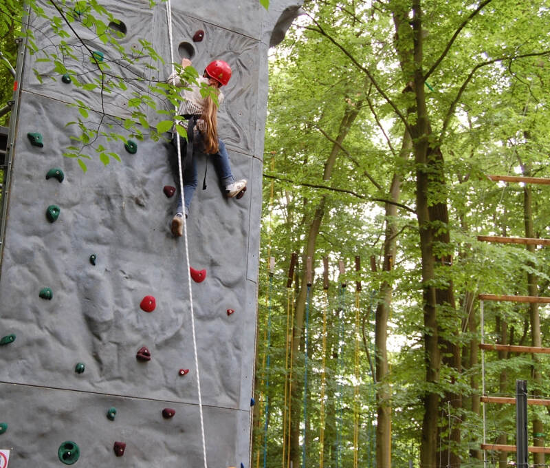 Eine Teilnehmerin an der Wand im Englisch-Klettercamp