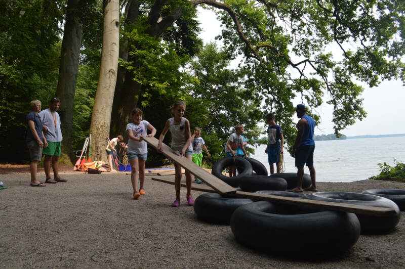 Kinder bauen ein Floß am Schweriner See im Englisch Sprachcamp in Wiligrad