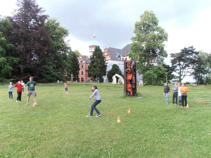 Kinder und Betreuer spielen gemeinsam im Grünen im Wiligrader Englisch Sprachcamp