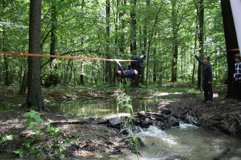 Kind auf Slackline über dem Fluss im Ferienlager Limbach
