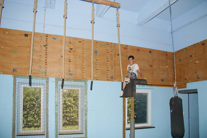 Ein Junge klettert in der Kletterhalle im Ferienlager in Limbach-Oberfrohna