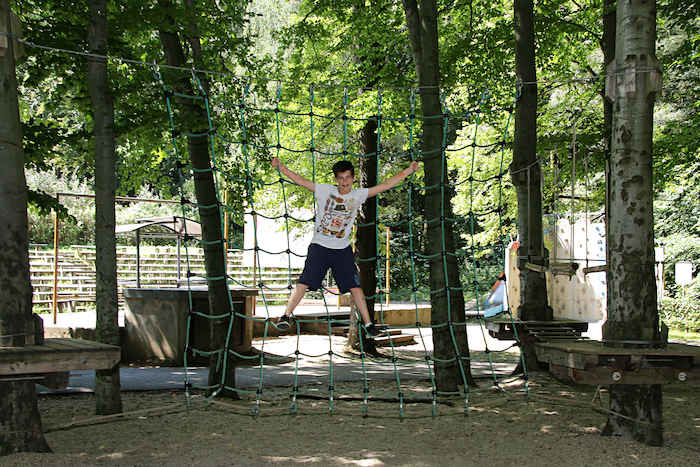 Junge hängt im Netz des Kletterwalds im Ferienlager in Limbach-Oberfrohna