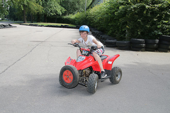 Junge posiert auf einem roten Quad im Ferienlager in Limbach-Oberfrohna