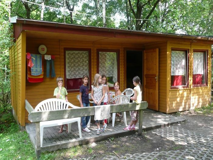 Kinder stehen vor einem Bungalow im Ferienlager in Limbach-Oberfrohna
