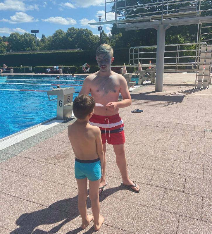 Zwei Jungs stehen im Schwimmbad am Beckenrand im Feriencamp
