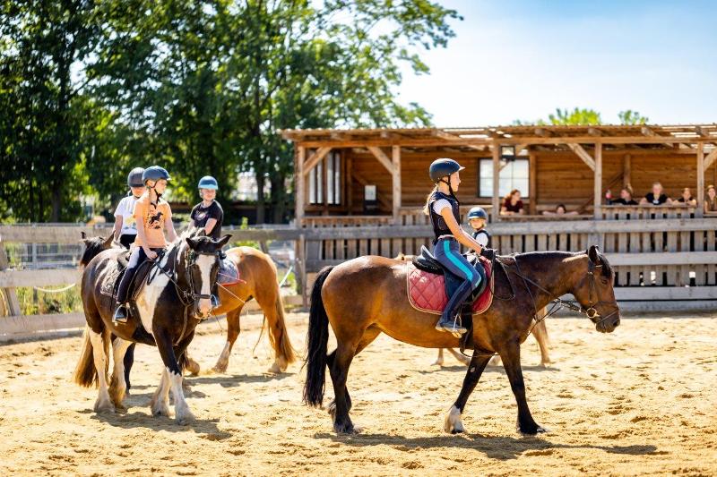 Mädchen reiten auf Pferden im Tagescamp.