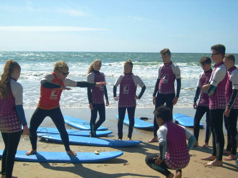 Surfer üben die Haltung am Strand im Surfcamp