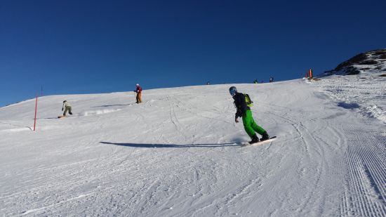 Un jeune s'essai au snowboard pendant une colonie de vacances ski ado
