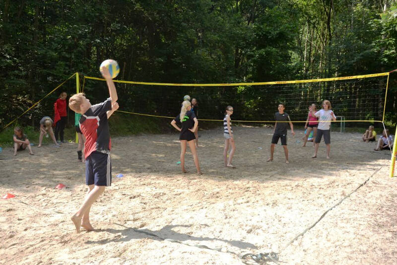 Die Kinder aus dem Ferienlager liefern sich ein Beachvolleyball-Match