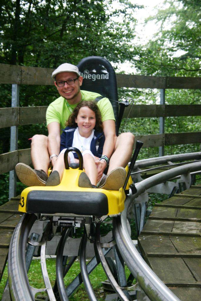 Zwei Teilnehmer eines Ferienlagers Westerwald fahren Sommerrodelbahn.