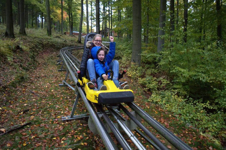 Ein Kind und eine Betreuerin auf der Sommerrodelbahn