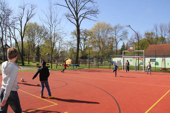 Kinder spielen auf dem Sportplatz im Ferienlager in Brandenburg