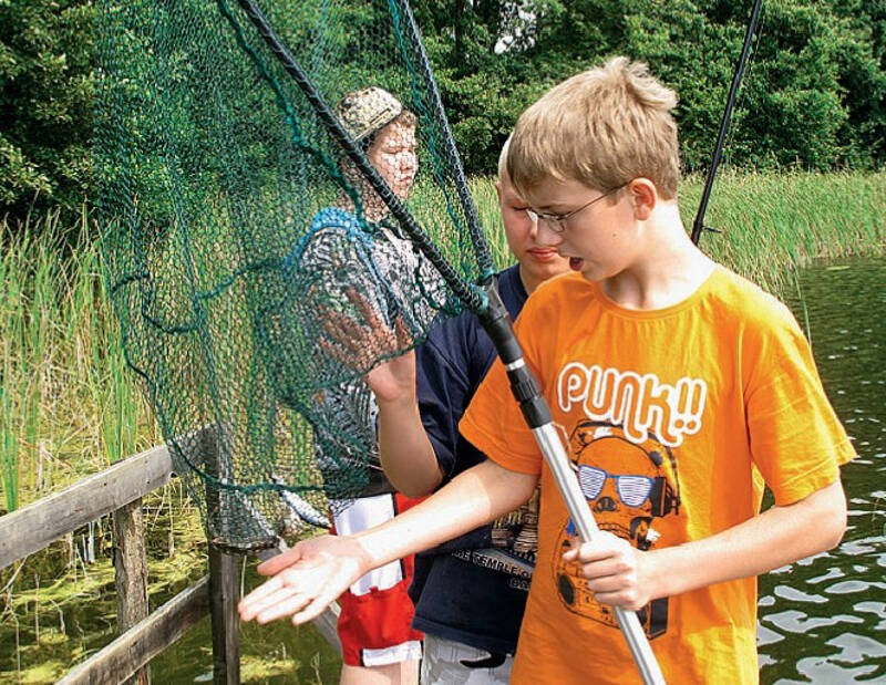 Jungs mit Fischen im Netz auf Kutzowsee Angelcamp Ferienlager