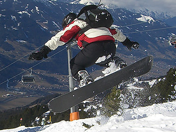 Ein Snowboarder macht vor spektakulärem Hintergrund einen Sprung