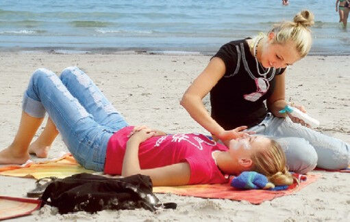 Mädchen cremen sich am Strand ein im Kiju Ostseecamp Juliusruh