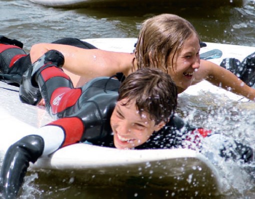 Jungs lachen beim Surfen im Surfcamp Peenemünde auf Usedom