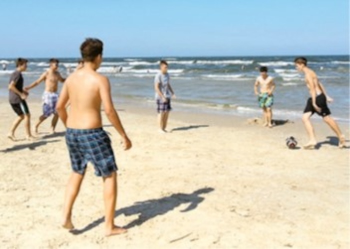 Jungs spielen Fußball am Strand im Ferienlager an der Ostsee