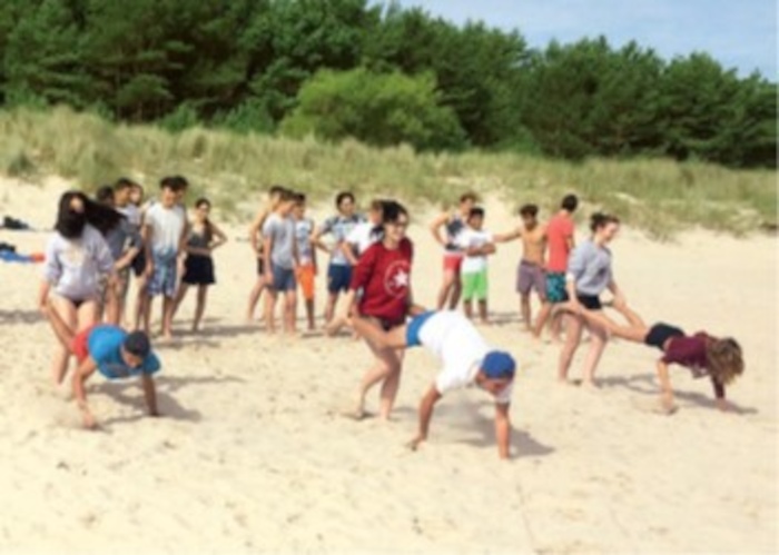 Kinder spielen Teamspiele am Strand im Ferienlager an der Ostsee