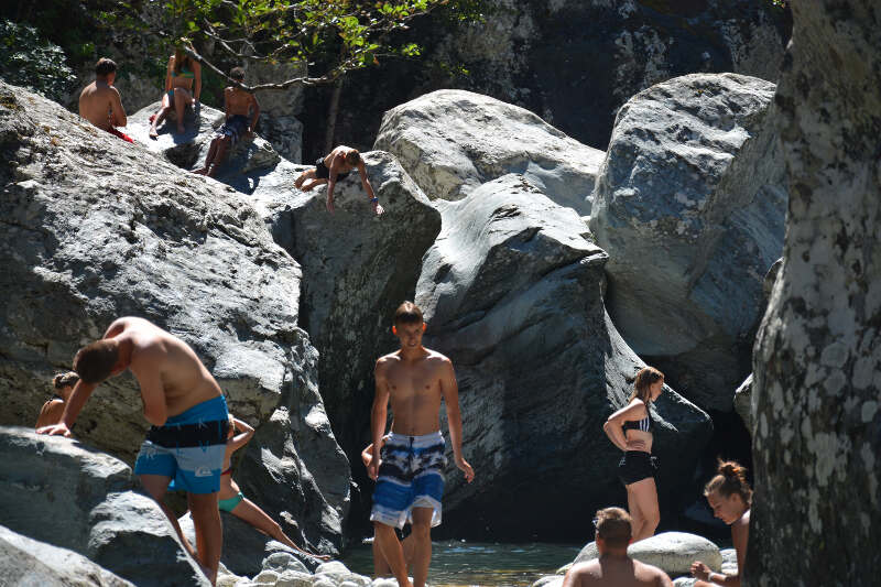 Jugendliche baden bei Felsen auf Ferienfreizeit Korsika