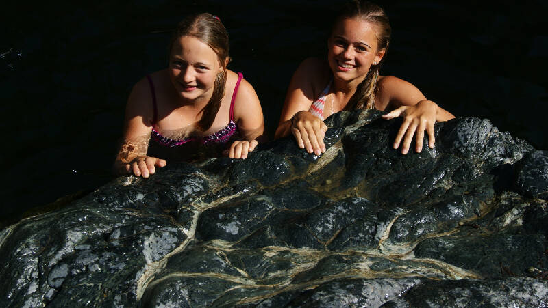 Mädchen baden an Felsen auf Ferienfreizeit Korsika