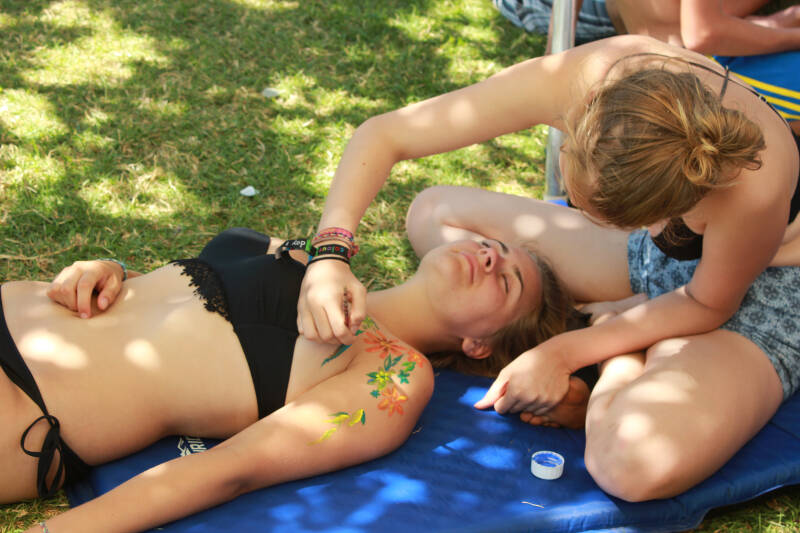 Mädchen bemalen sich beim Chillen in der Sonne auf Ferienfreizeit Korsika