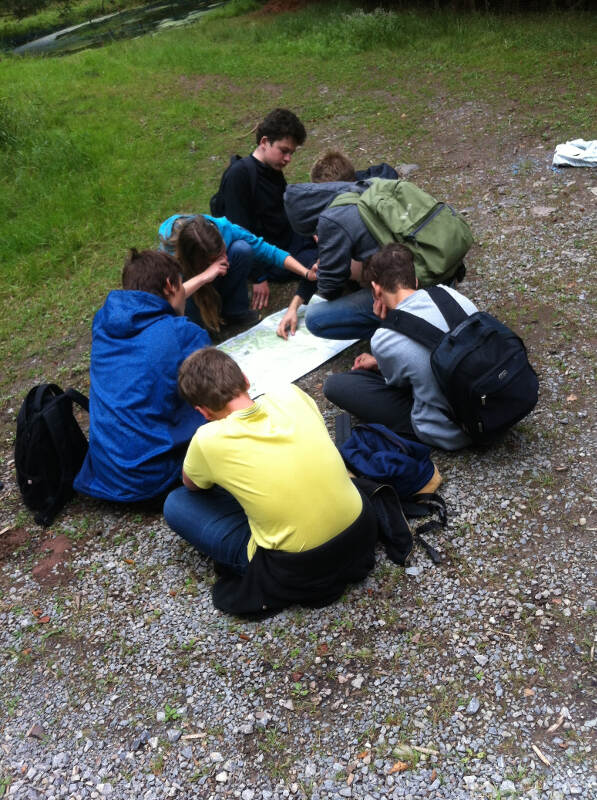 Gruppe plant an einer Karte ihre Route in der Kinderfreizeit Bayern