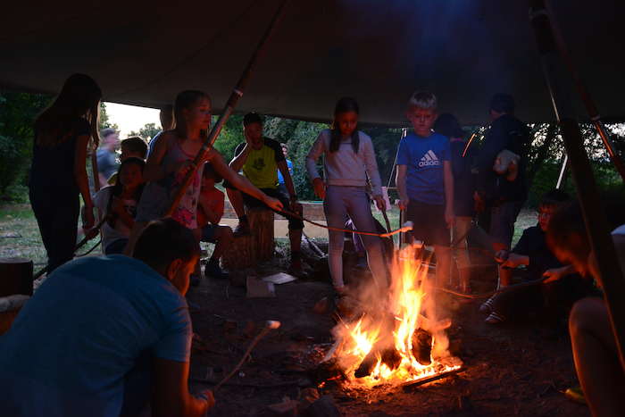 Kinder grillen am Lagerfeuer bei einem Sprachcamp Englisch Deutschland