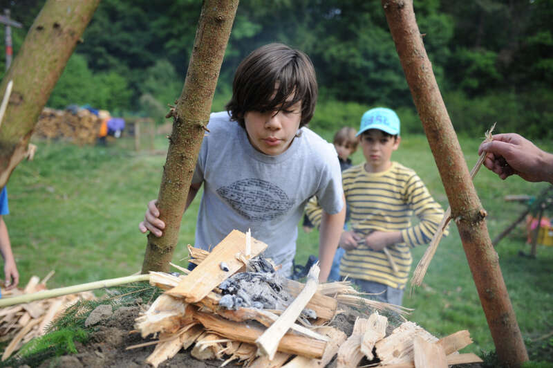 Kinder des Ferienprogramms Nürnberg Herbstferien machen ein Lagerfeuer