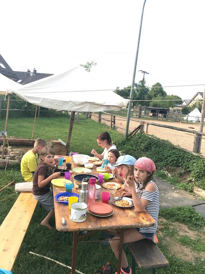 Kinder des Abenteuer Sportcamps Vorarlberg essen gemeinsam
