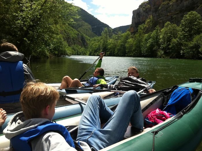 Gruppe chillt auf den Booten im Wasser auf der Kanutour Frankreich