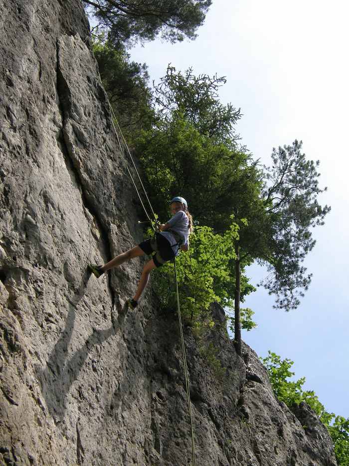 Mädchen klettert an Felsen im Klettercamp Bayern