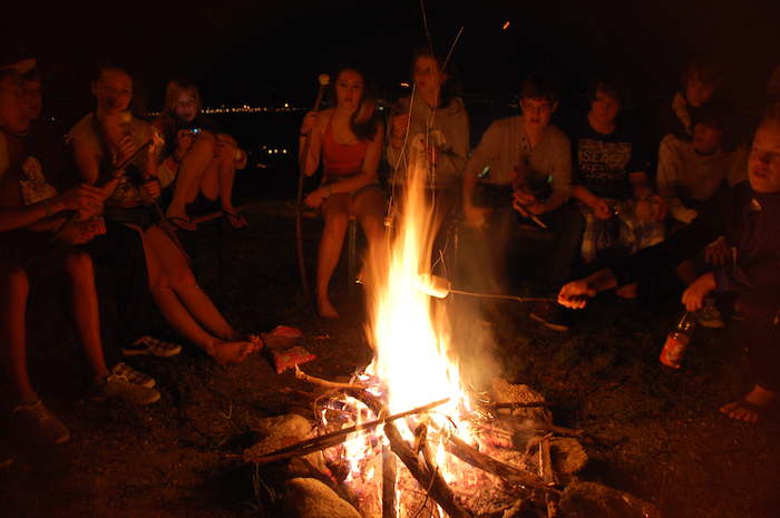 Teilnehmer eines Feriencamps Allgäu machen Stockbrot