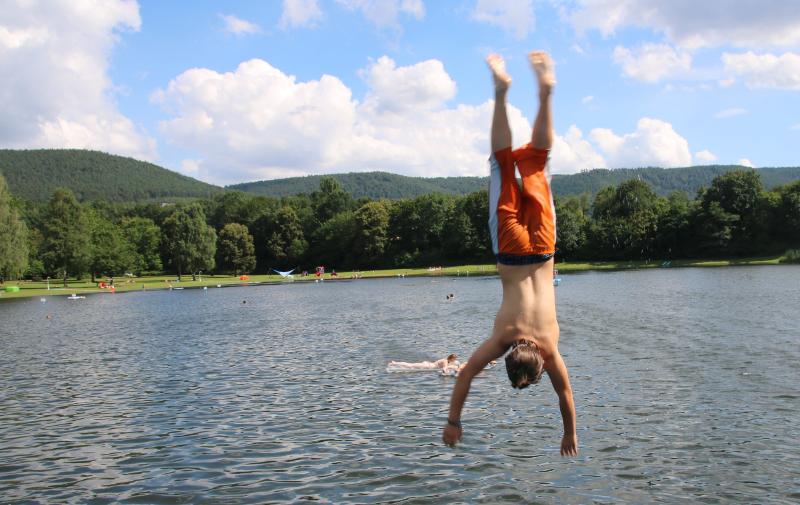 Ein Junge des Ferienprogramms München springt ins Wasser