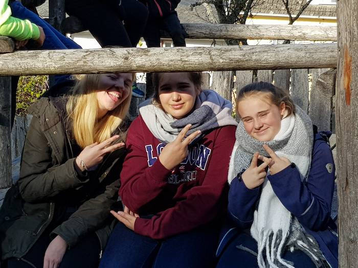 Bei dem Saarland Ferienprogramm sitzen drei Mädchen zusammen und genießen die Sonne