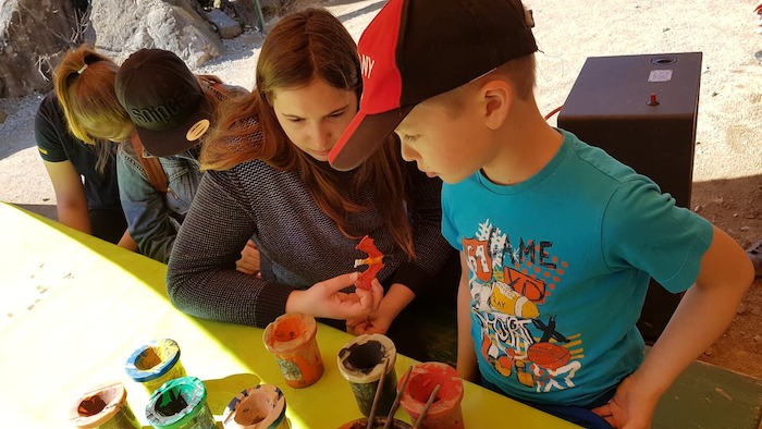 Junge und Mädchen basteln auf der Ferienfreizeit in Rheinland-Pfalz