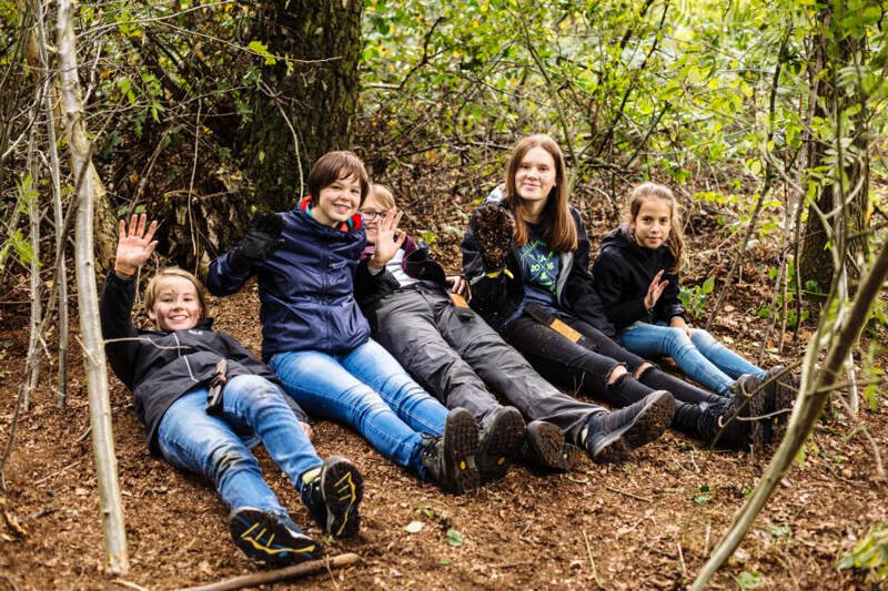 Kinder eines Jugend Naturcamps legen eine kurze Pause ein