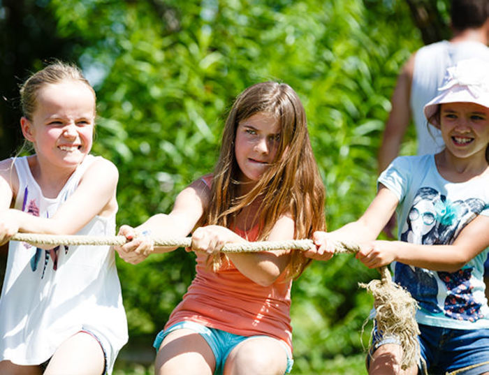 Mädchen spielen konzentriert Tauziehen im Feriencamp Stuttgart