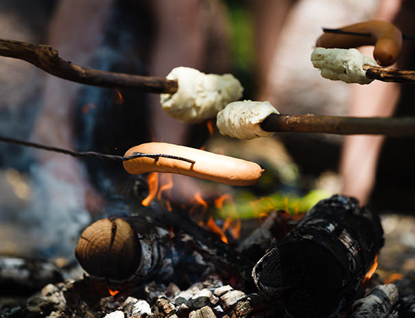 Würste und Stockbrot grillen über dem Lagerfeuer im Ferienlager Stuttgart