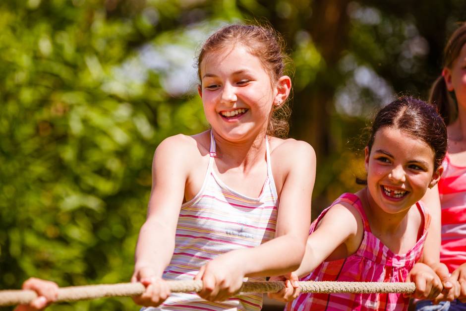 Einige Kinder duellieren sich beim Tauziehen bei schönsten Osterwetter im Draußen und haben eine Menge Spaß bei den Osterferien in der Jugendherberge 