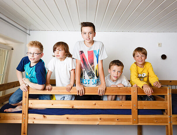 Jungs toben im Bett im Ferienlager Sonnenhof.