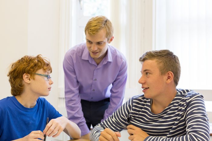 Jungs eines Jugendherberge Feriencamps lernen Englisch