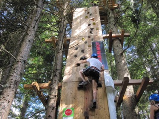 Junge erklimmt Kletterwand im Activitycamp in Österreich