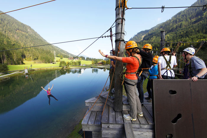 Des jeunes font de la tyrolienne pendant leur camp de vacances d'été
